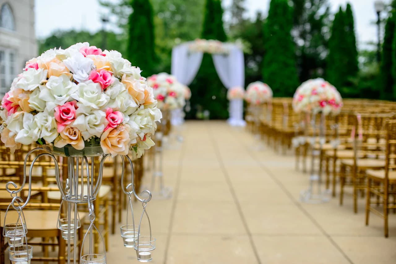 A flower-lined wedding aisle in an outdoor garden